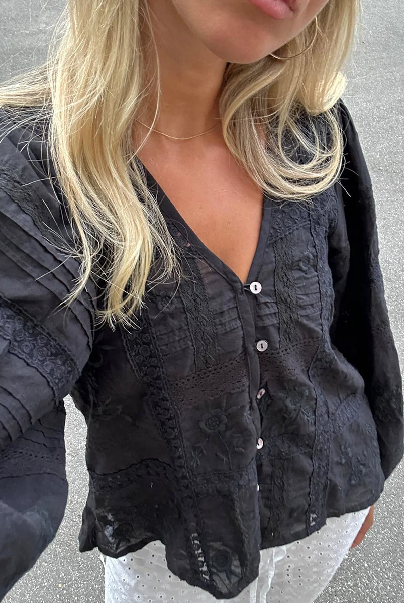Luźna, kobieca koszula Mabel Almost Black marki SISSEL EDELBO z bufiastymi rękawami i dekoltem w serek z plisą zapinaną na małe guziki z masy perłowej i elastyczną pętelkę. Ozdobiona piękną koronkową taśmą i kwiatowym haftem w różnych miejscach. Wykonana w 100% z bawełny organicznej.
-Luźny fason
-Bufiaste rękawy
-Zamów bluzkę w swoim standardowym rozmiarze