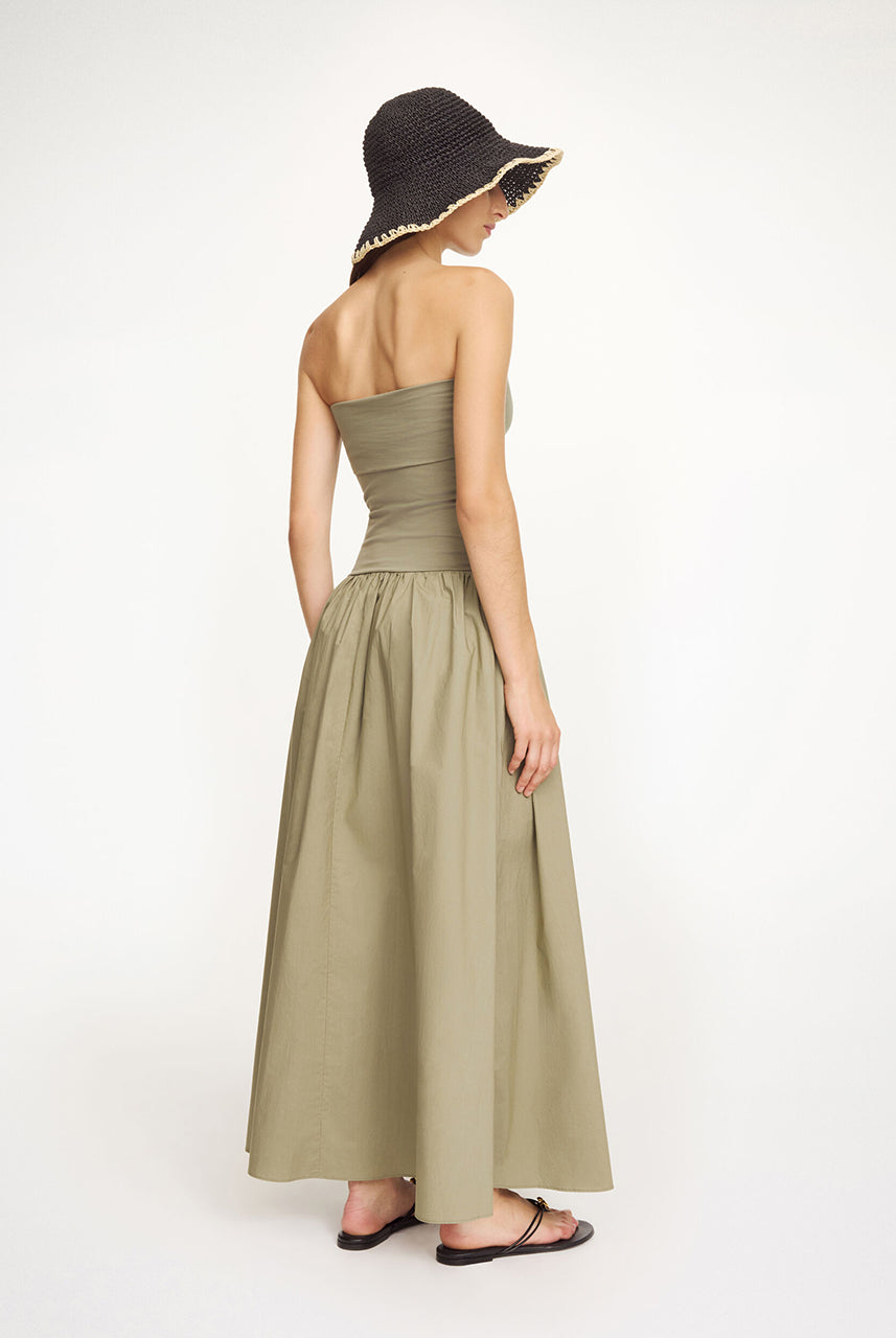 Minimalistyczna sukienka Marc Deep Lichen Green By Malene Birger z górną, dopasowaną, marszczoną cześcią bez ramiączek. Od linii bioder materiał przechodzi w luźną, obszerną spódnicę o długości maxi. Całość tworzy kształt litery A. Wykonana z bawełny organicznej. To idealna propozycja na wiosenno-letnie dni.
-Długość maxi
-Bawełna organiczna
-Zamów sukienkę w swoim standardowym rozmiarze 