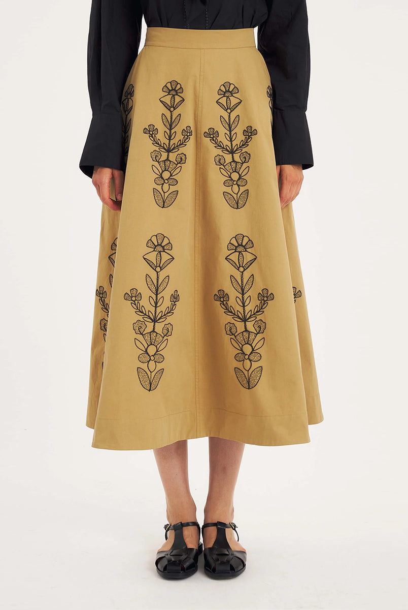 Rozkloszowana, trapezowa spódnica Maria Beige marki Antik Batik o klasycznej długości midi, sięgającej do połowy łydki. Ma wysoką, gładką talię z wyraźnie zaznaczonym, szerokim pasem. Głównym elementem dekoracyjnym są duże, pionowe hafty roślinne i kwiatowe w ciemnym kolorze. Haft układa się symetrycznie, w pionowe rzędy, co optycznie wydłuża sylwetkę i nadaje całości tradycyjny, rzemieślniczy charakter.
-Długość midi
-Wysoki stan
-Ozdobne hafty kwiatowe i roślinne
-Zamów spódnicę w swoim standard