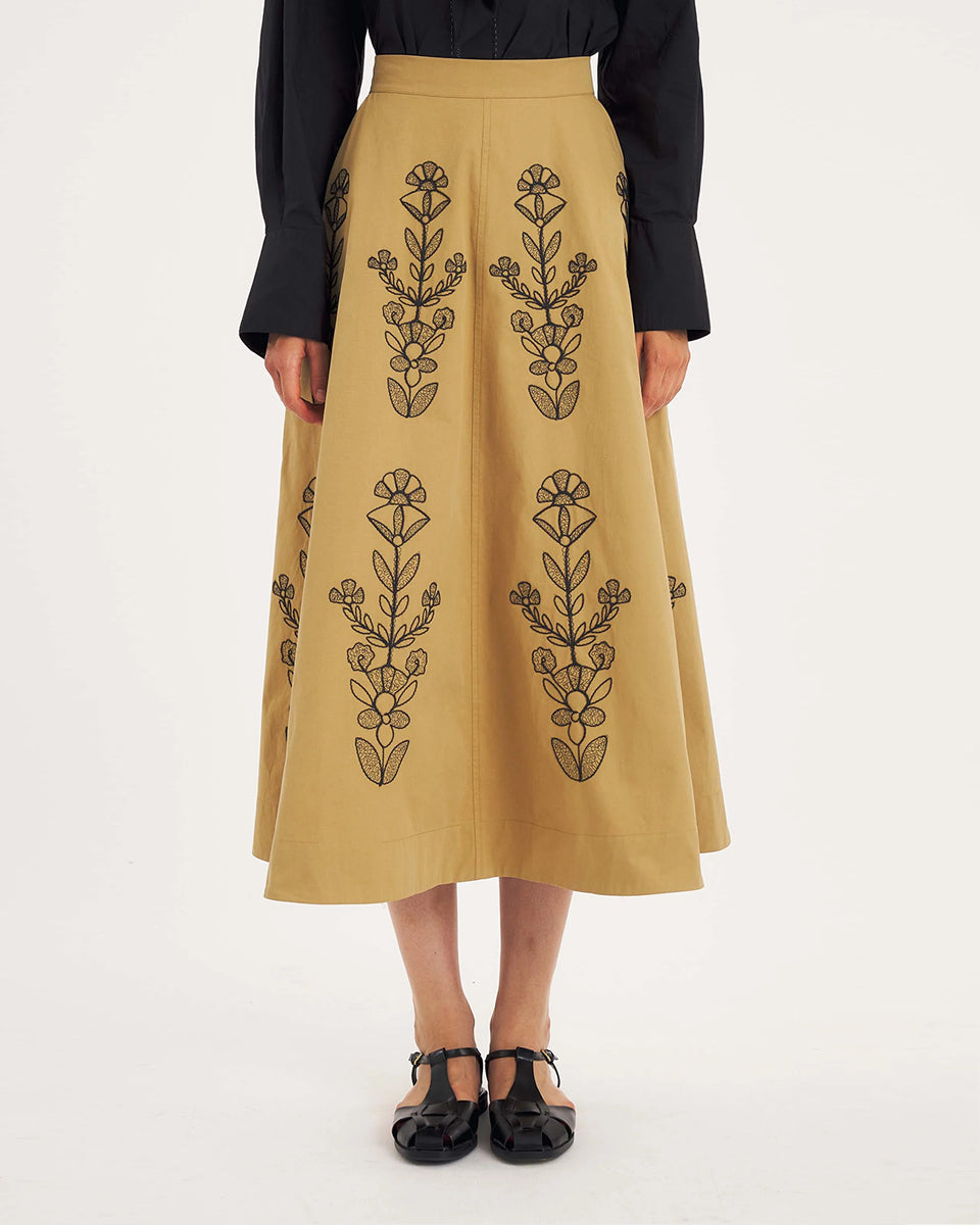 Rozkloszowana, trapezowa spódnica Maria Beige marki Antik Batik o klasycznej długości midi, sięgającej do połowy łydki. Ma wysoką, gładką talię z wyraźnie zaznaczonym, szerokim pasem. Głównym elementem dekoracyjnym są duże, pionowe hafty roślinne i kwiatowe w ciemnym kolorze. Haft układa się symetrycznie, w pionowe rzędy, co optycznie wydłuża sylwetkę i nadaje całości tradycyjny, rzemieślniczy charakter.
-Długość midi
-Wysoki stan
-Ozdobne hafty kwiatowe i roślinne
-Zamów spódnicę w swoim standard
