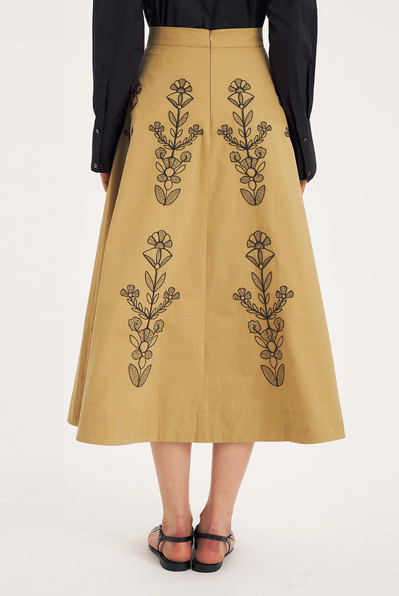 Rozkloszowana, trapezowa spódnica Maria Beige marki Antik Batik o klasycznej długości midi, sięgającej do połowy łydki. Ma wysoką, gładką talię z wyraźnie zaznaczonym, szerokim pasem. Głównym elementem dekoracyjnym są duże, pionowe hafty roślinne i kwiatowe w ciemnym kolorze. Haft układa się symetrycznie, w pionowe rzędy, co optycznie wydłuża sylwetkę i nadaje całości tradycyjny, rzemieślniczy charakter.
-Długość midi
-Wysoki stan
-Ozdobne hafty kwiatowe i roślinne
-Zamów spódnicę w swoim standard