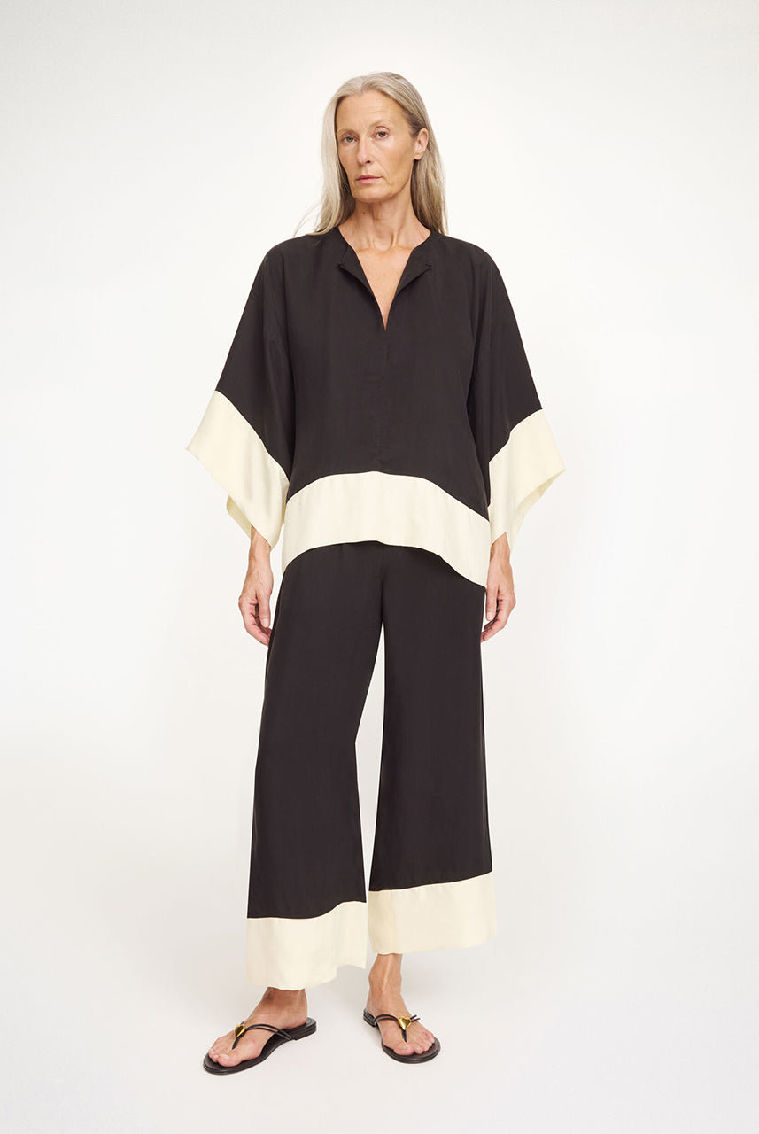 Eleganckie, zwiewne spodnie Mirabello Black White By Malene Birger z elastyczną talią z wysoką gumką w pasie i szerokimi nogawkami. Posiadają kieszenie boczne i kontrastowe wykończenia nogawek. Spodnie mają luźny krój. Wykonane z mieszanki cupro.
-Luźny, zwiewny fason
-Elastyczna talia
-Zamów spodnie w swoim standardowym rozmiarze