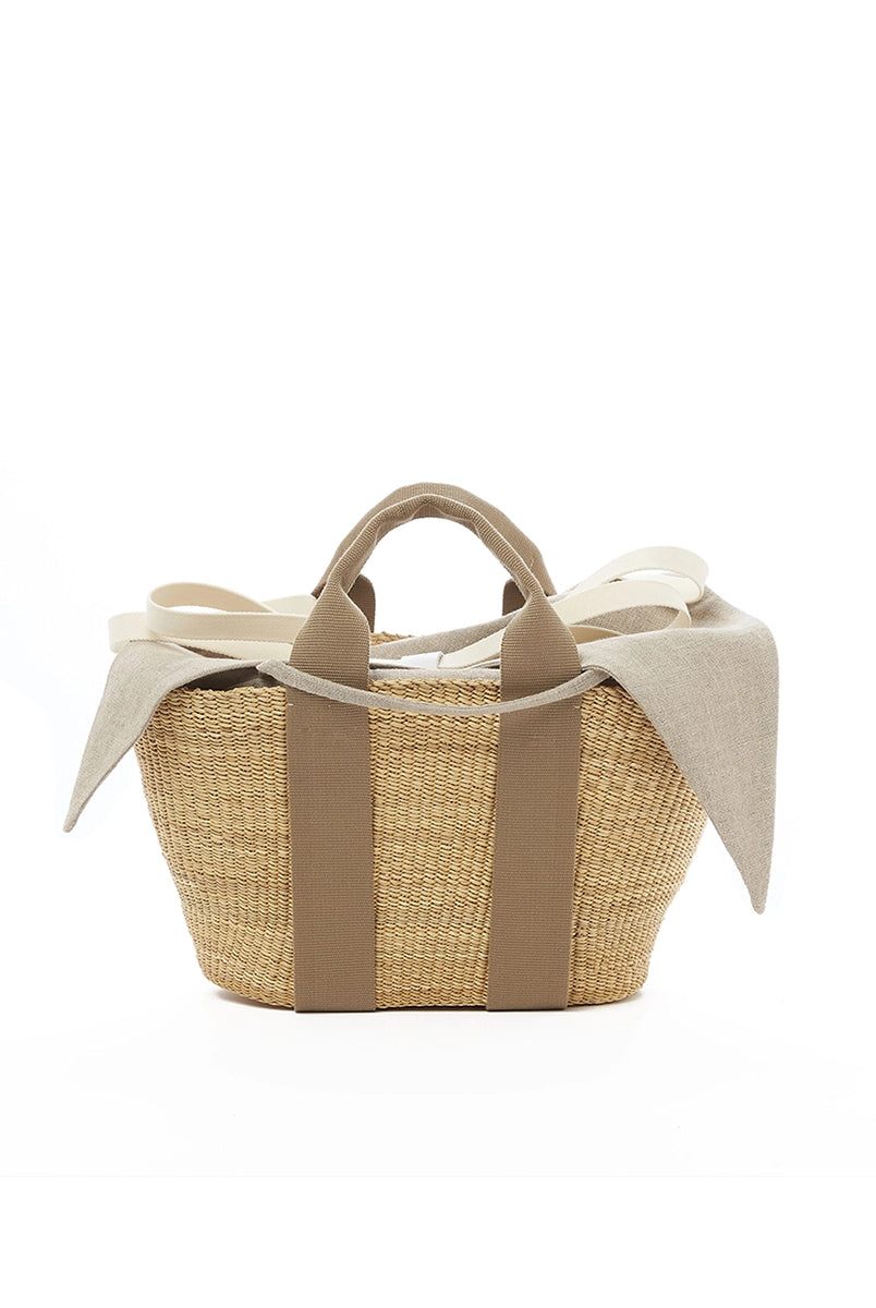 Średniej wielkości, ręcznie pleciony kosz GEORGE - NATURAL x BEIGE HDL x NATURAL LINEN francuskiej marki Muun. Posiada trapezowy kształt, dwie mocne, materiałowe rączki do wygodnego trzymania w dłoni oraz długi, cienki pasek do zawieszenia na ramieniu.