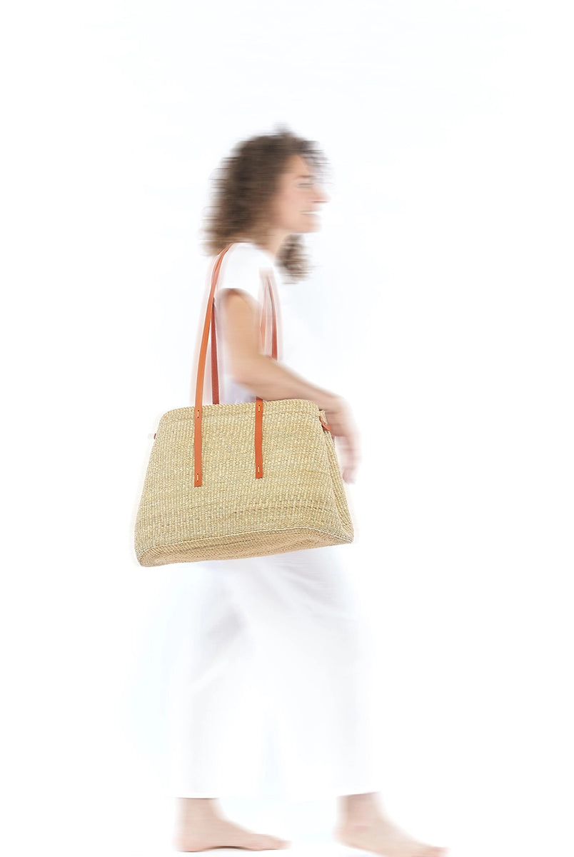 Duży, ręcznie pleciony kosz LAURA - NATURAL x TAN HDL x ECRU COTTON francuskiej marki Muun. Posiada trapezowy kształt, dwie mocne, skórzane rączki w kolorze do wygodnego trzymania w dłoni i zawieszenia na ramieniu. Wewnątrz koszyka znajduje się wiązana, wyciągana bawełniana, kremowa torebka.