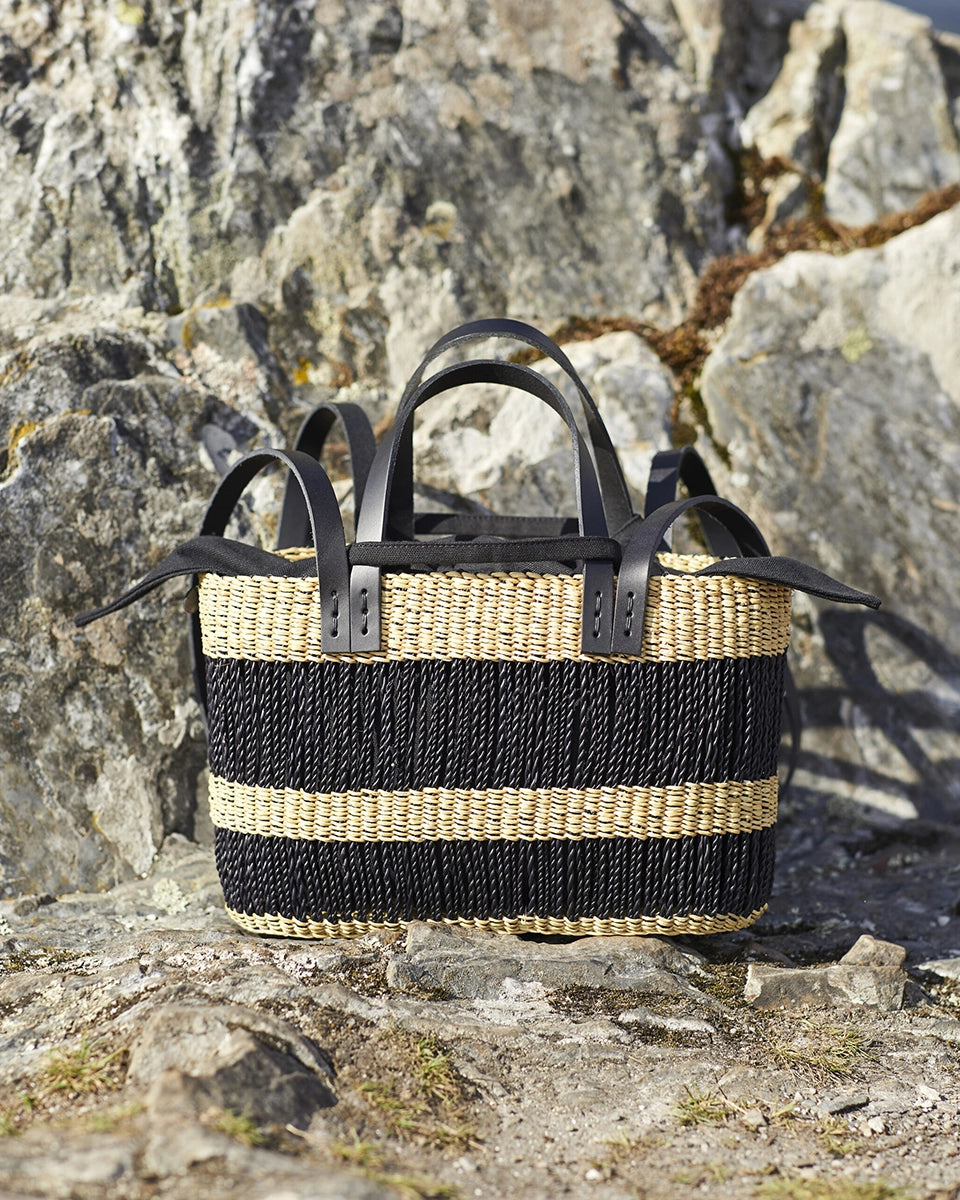 Mała, ręcznie pleciona torebka koszykw grube, czarne pasy MARCUS - NATURAL x BLACK HDL x BLACK COTTON francuskiej marki Muun. Posiada prostokątny kształt, dwie mocne, skórzane rączki do wygodnego trzymania w dłoni i długi pasek do zawieszenia na ramieniu.