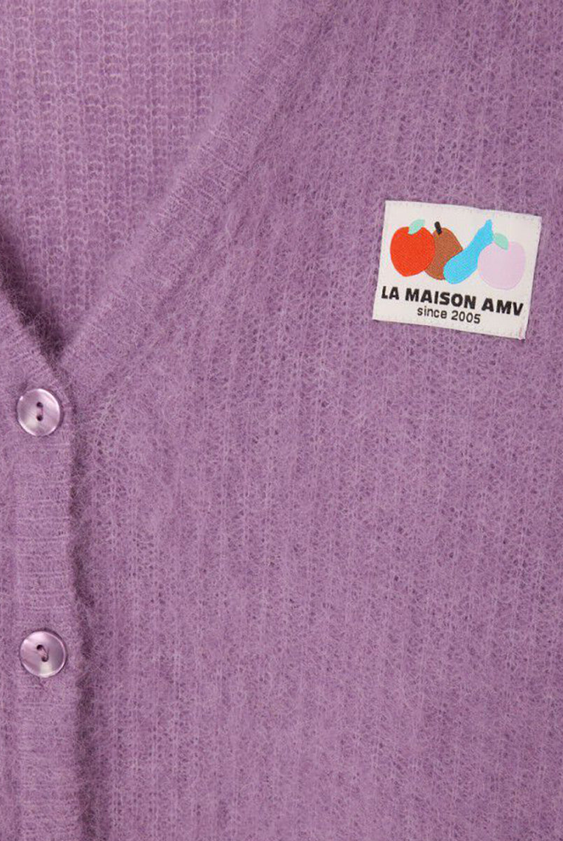 Oversizowy, miękki kardigan Nenybay Violet marki American Vintage z długim rękawem i dekoltem w serek. Zapinany na guziki. Posiada naszywkę z logo na piersi. Zakończony ściągaczami. Wykonany z lekkiej dzianiny z alpaką. Noś go samodzielnie lub połącz z innymi elementami garderoby, aby stworzyć warstwowy, codzienny look. 