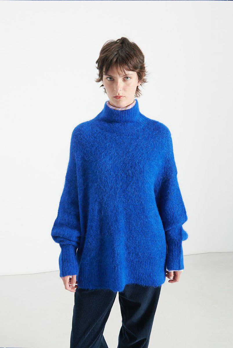 Gruby, luźny sweter Niby Blue Marl marki American Vintage z długim rękawem i golfem. Zakończony ściągaczami. Wykonany z ultraciepłej, miękkiej dzianiny z alpaką. Noś go z jeansami lub spódnicą, aby uzyskać swobodny look. 