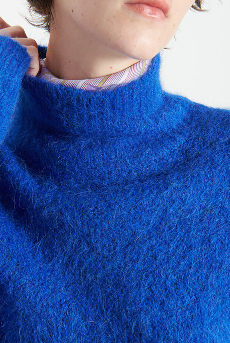 Gruby, luźny sweter Niby Blue Marl marki American Vintage z długim rękawem i golfem. Zakończony ściągaczami. Wykonany z ultraciepłej, miękkiej dzianiny z alpaką. Noś go z jeansami lub spódnicą, aby uzyskać swobodny look. 