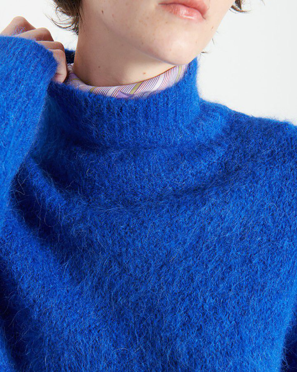 Gruby, luźny sweter Niby Blue Marl marki American Vintage z długim rękawem i golfem. Zakończony ściągaczami. Wykonany z ultraciepłej, miękkiej dzianiny z alpaką. Noś go z jeansami lub spódnicą, aby uzyskać swobodny look. 