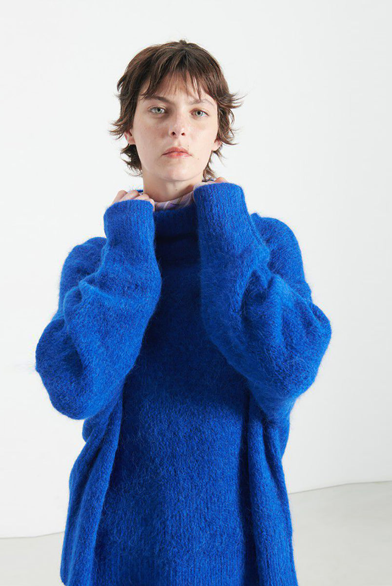 Gruby, luźny sweter Niby Blue Marl marki American Vintage z długim rękawem i golfem. Zakończony ściągaczami. Wykonany z ultraciepłej, miękkiej dzianiny z alpaką. Noś go z jeansami lub spódnicą, aby uzyskać swobodny look. 