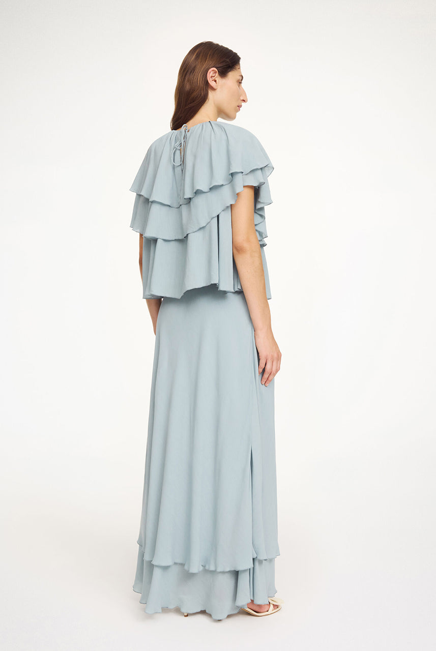 Luźny, błękitny top Nina Arona Blue By Malene Birger z okrągłym dekoltem i wiązaniem z tyłu. Składa się z kilku, półprzezroczystych warstw. Pierwsza falbana opada na ramiona, tworząc efekt 'rękawa skrzydełka'. Wykonany z wiskozy.
-Luźny, swobodny fason
-Bez rękawów
-Zamów w swoim standardowym rozmiarze 