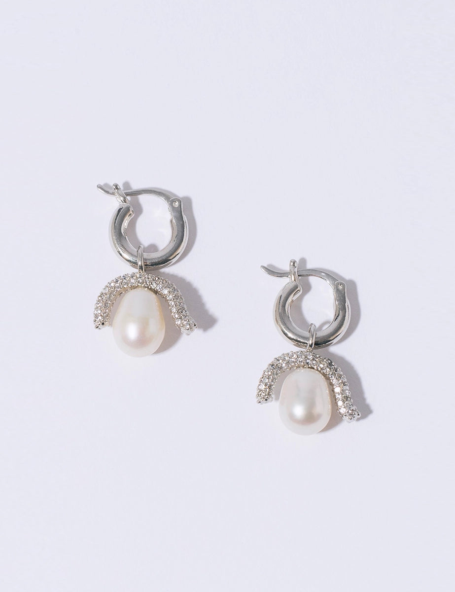 Efektowne, wiszące kolczyki PEARL OCTOPUSS.Y BABY PARIS SILVER z angielskim zapięciem. Złożone z grubego kółka i ściąganej zawieszki z dużą, naturalną perłą i połyskującym elementem wysadzanym drobnymi kryształami.