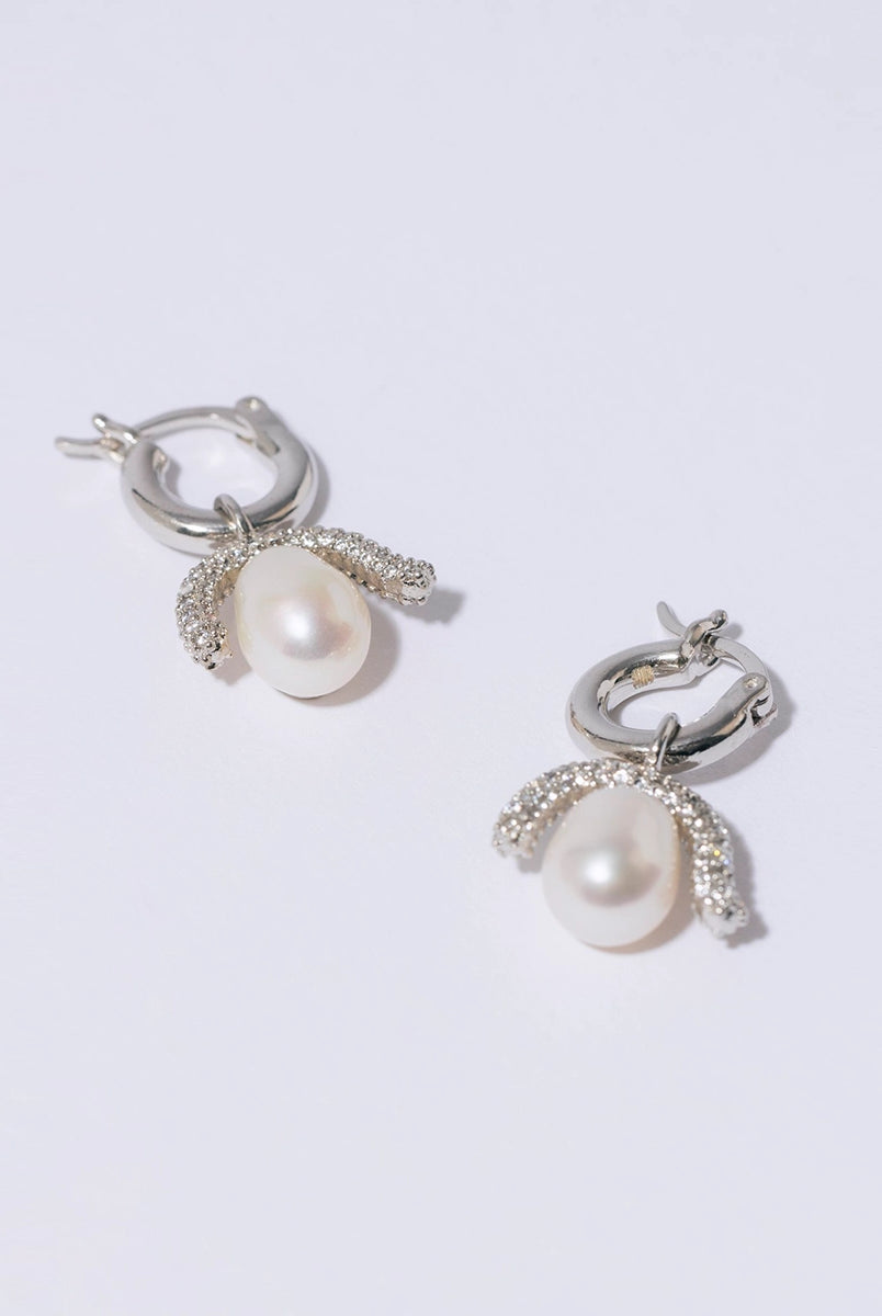 Efektowne, wiszące kolczyki PEARL OCTOPUSS.Y BABY PARIS SILVER z angielskim zapięciem. Złożone z grubego kółka i ściąganej zawieszki z dużą, naturalną perłą i połyskującym elementem wysadzanym drobnymi kryształami.