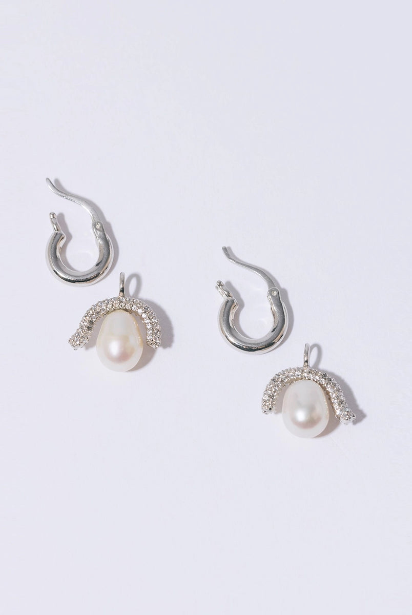 Efektowne, wiszące kolczyki PEARL OCTOPUSS.Y BABY PARIS SILVER z angielskim zapięciem. Złożone z grubego kółka i ściąganej zawieszki z dużą, naturalną perłą i połyskującym elementem wysadzanym drobnymi kryształami.