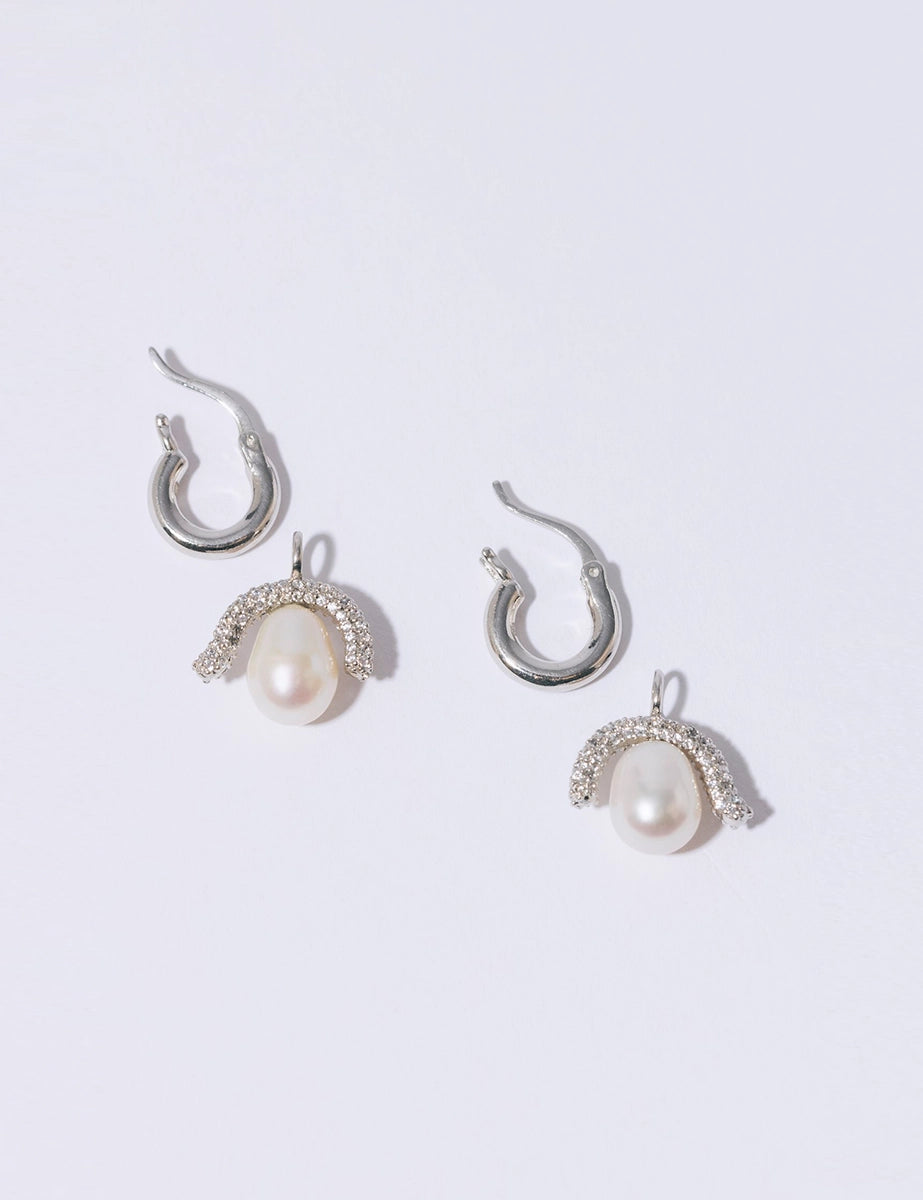 Efektowne, wiszące kolczyki PEARL OCTOPUSS.Y BABY PARIS SILVER z angielskim zapięciem. Złożone z grubego kółka i ściąganej zawieszki z dużą, naturalną perłą i połyskującym elementem wysadzanym drobnymi kryształami.