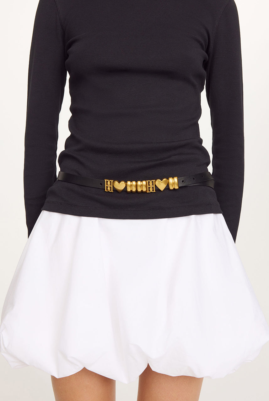 Skórzany, cienki pasek Ounlas Black By Malene Birger ze złotymi akcentami w kształcie serduszek i monogramów. Posiada regulowane zapięcie na klamrę. Wykonany z ziarnistej skóry. Idealny do sukienki i spodni stanem. 