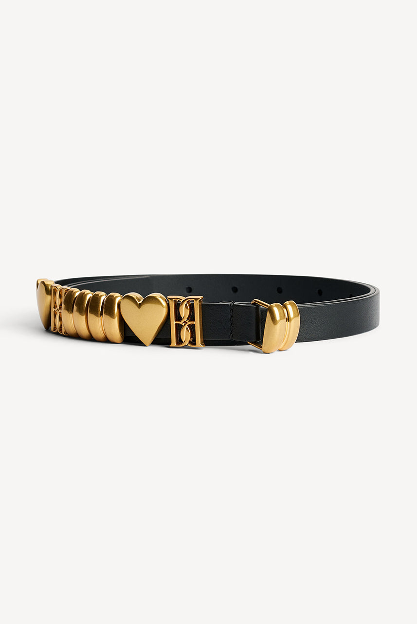 Skórzany, cienki pasek Ounlas Black By Malene Birger ze złotymi akcentami w kształcie serduszek i monogramów. Posiada regulowane zapięcie na klamrę. Wykonany z ziarnistej skóry. Idealny do sukienki i spodni stanem. 