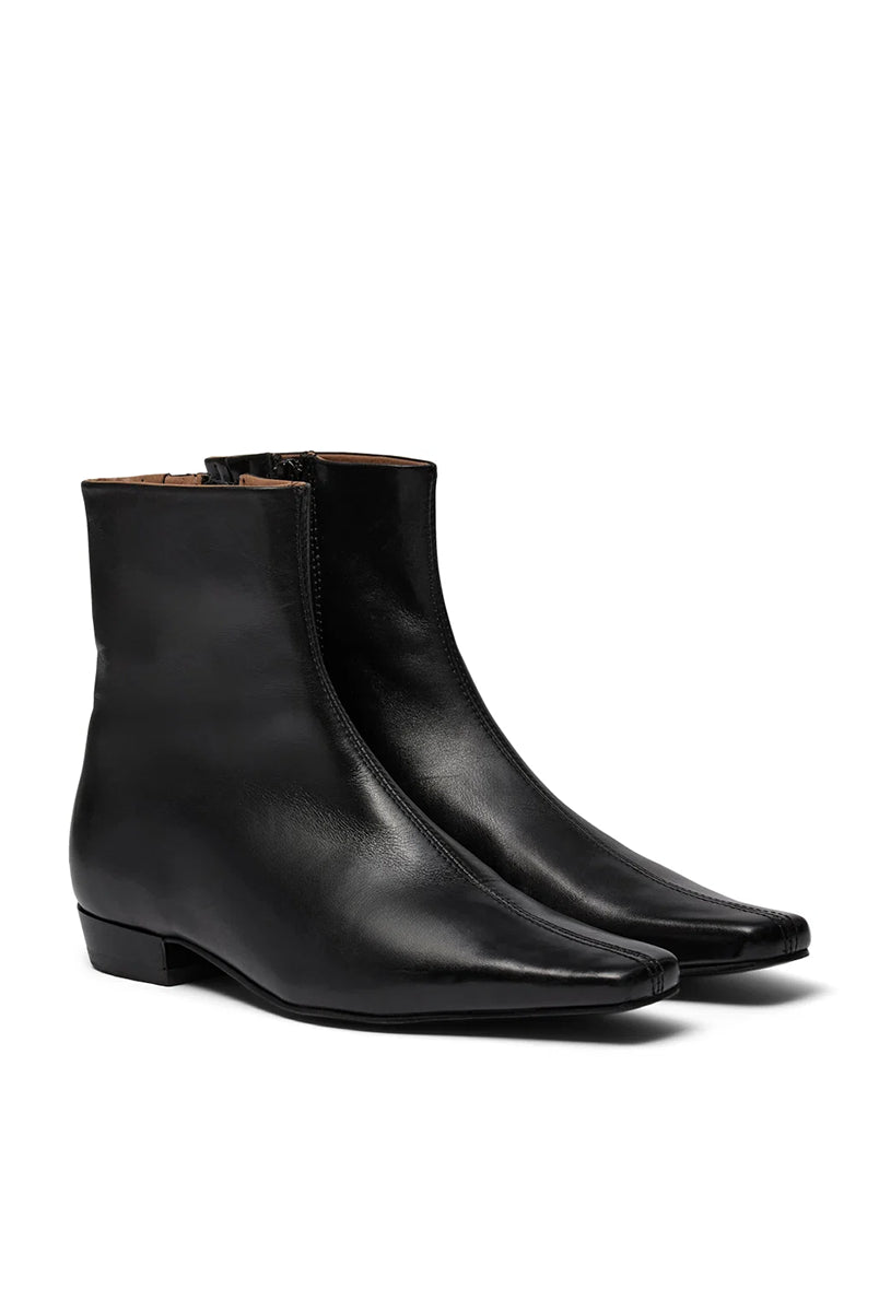 Eleganckie, czarne botki PAisla Black o minimalistycznym i nowoczesnym designie. Mają gładką cholewkę sięgającą ponad kostkę, z dyskretnym zamkiem błyskawicznym umieszczonym z boku. Ich najbardziej charakterystycznym elementem jest wyraźnie zarysowany, kwadratowy nosek, który nadaje całości geometrycznego, modnego charakteru. Mają niski, płaski obcas.
-Rozmiarówka jest standardowa. Zamów buty w rozmiarze, który zazwyczaj nosisz.