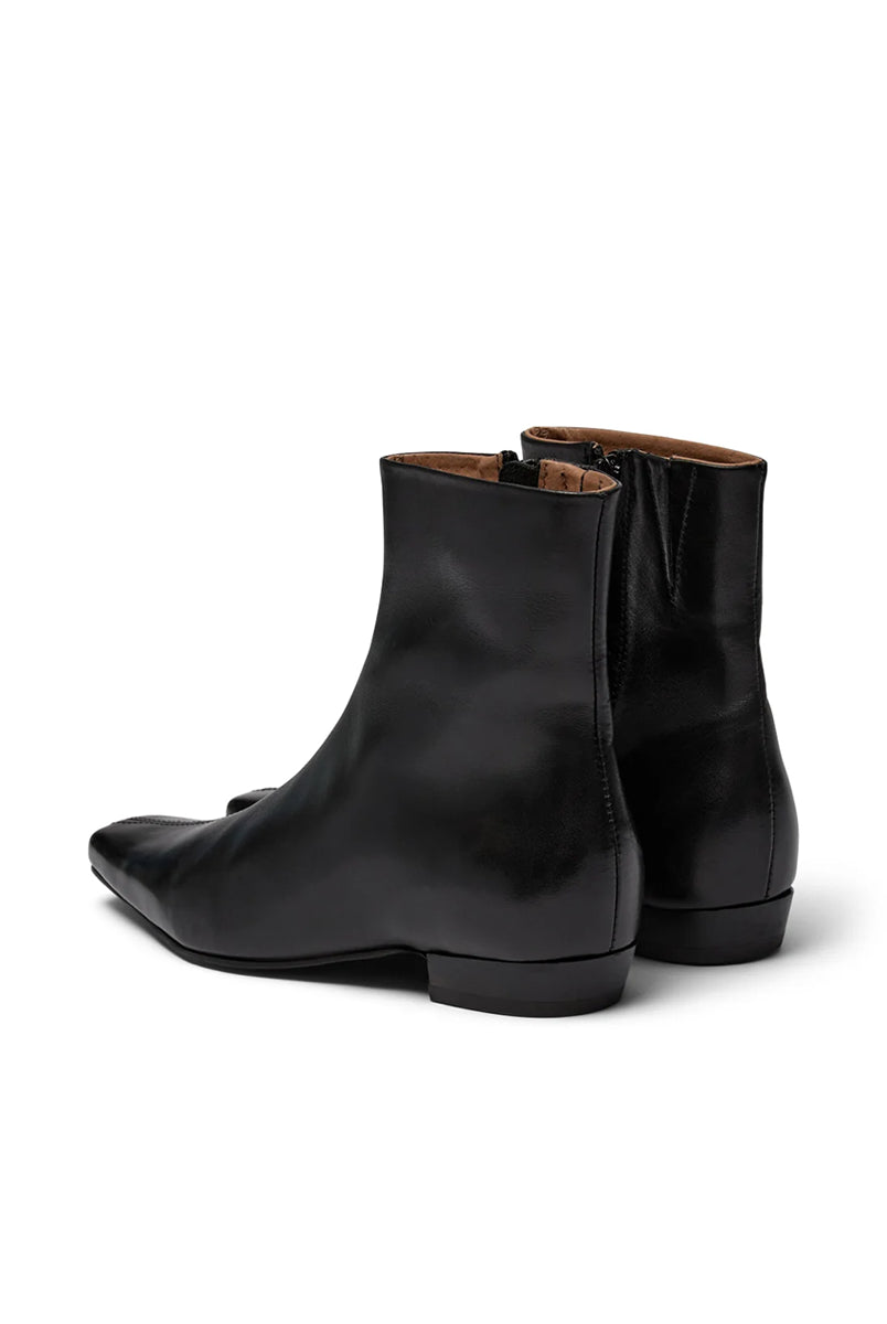 Eleganckie, czarne botki PAisla Black o minimalistycznym i nowoczesnym designie. Mają gładką cholewkę sięgającą ponad kostkę, z dyskretnym zamkiem błyskawicznym umieszczonym z boku. Ich najbardziej charakterystycznym elementem jest wyraźnie zarysowany, kwadratowy nosek, który nadaje całości geometrycznego, modnego charakteru. Mają niski, płaski obcas.
-Rozmiarówka jest standardowa. Zamów buty w rozmiarze, który zazwyczaj nosisz.