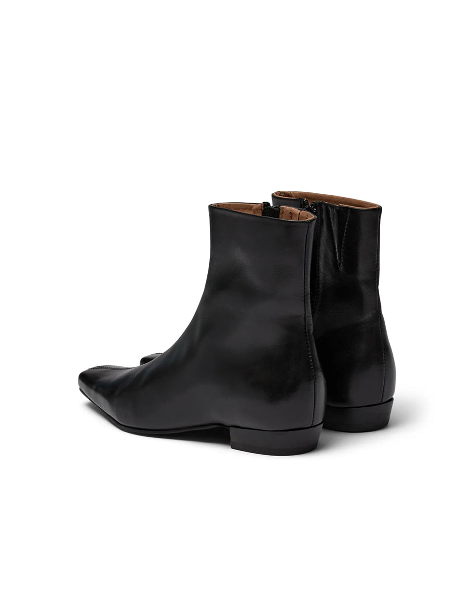 Eleganckie, czarne botki PAisla Black o minimalistycznym i nowoczesnym designie. Mają gładką cholewkę sięgającą ponad kostkę, z dyskretnym zamkiem błyskawicznym umieszczonym z boku. Ich najbardziej charakterystycznym elementem jest wyraźnie zarysowany, kwadratowy nosek, który nadaje całości geometrycznego, modnego charakteru. Mają niski, płaski obcas.
-Rozmiarówka jest standardowa. Zamów buty w rozmiarze, który zazwyczaj nosisz.
