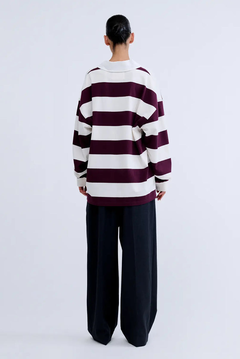 Luźny longsleeve z długim rękawem Paul Stripes Love Stories o ponadczasowym wzorze w kremowo-bordowe paski. Posiada kołnierzyk zapinany na guziki. Nad prawą piersią znajduje się niewielkie logo marki. Wykonany z lekkiej bawełny, zapewnia komfort noszenia przez cały dzień. Jest wszechstronnym elementem garderoby, który łatwo zestawić zarówno z codziennymi, jak i bardziej eleganckimi stylizacjami.
