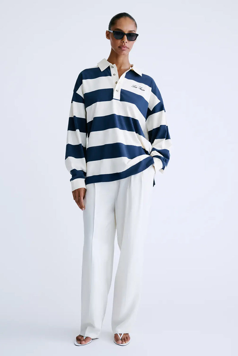 Longsleeve z długim rękawem Paul Stripes Love Stories o ponadczasowym wzorze w kremowo-granatowe paski. Posiada kołnierzyk zapinany na guziki. Nad prawą piersią znajduje się niewielkie logo marki. Wykonany z lekkiej bawełny, zapewnia komfort noszenia przez cały dzień. Jest wszechstronnym elementem garderoby, który łatwo zestawić zarówno z codziennymi, jak i bardziej eleganckimi stylizacjami.