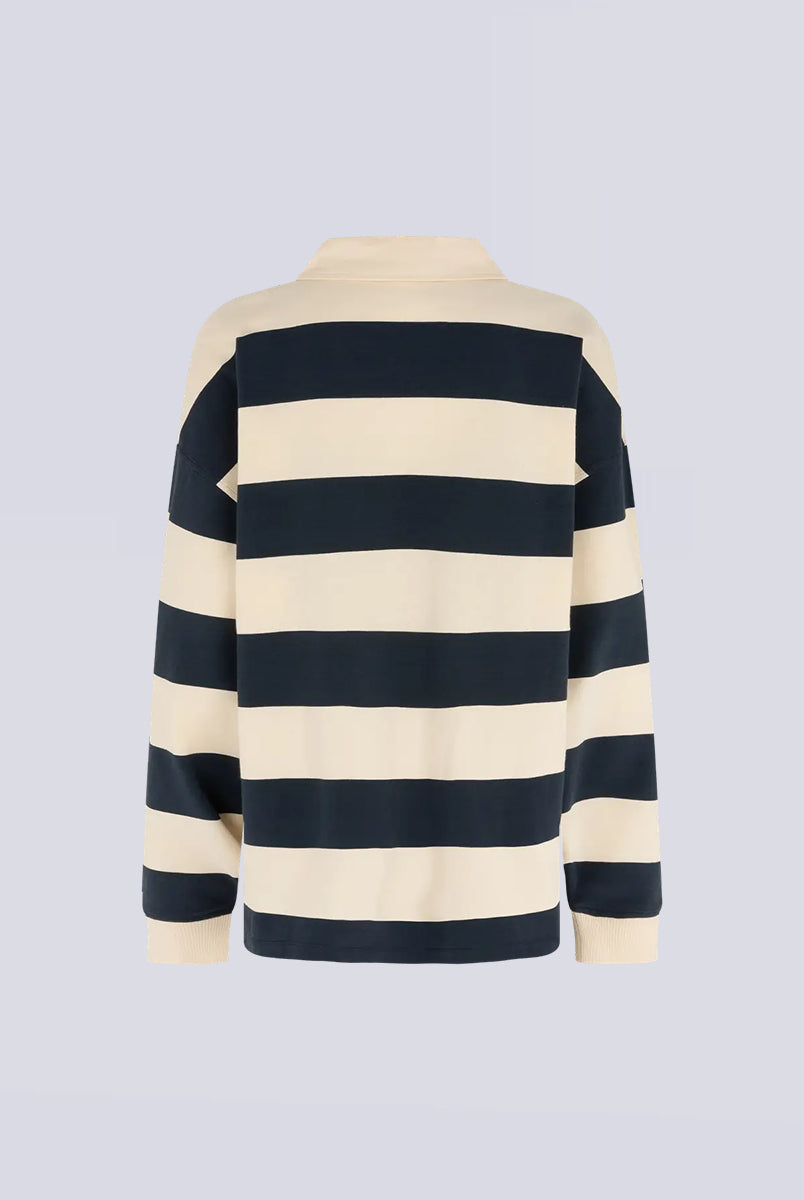 Longsleeve z długim rękawem Paul Stripes Love Stories o ponadczasowym wzorze w kremowo-granatowe paski. Posiada kołnierzyk zapinany na guziki. Nad prawą piersią znajduje się niewielkie logo marki. Wykonany z lekkiej bawełny, zapewnia komfort noszenia przez cały dzień. Jest wszechstronnym elementem garderoby, który łatwo zestawić zarówno z codziennymi, jak i bardziej eleganckimi stylizacjami.