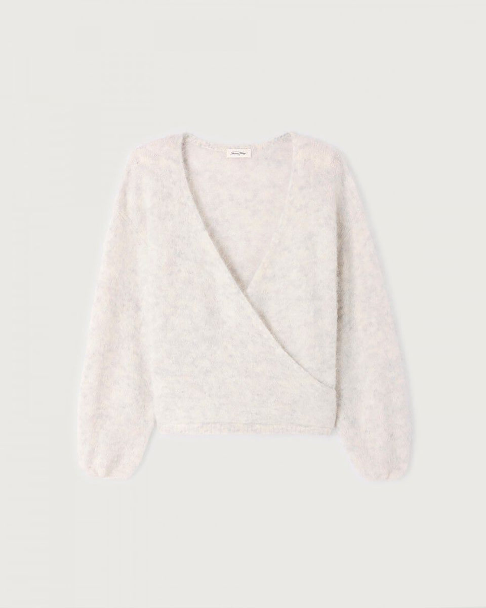 Miękki, krótki sweter NUN18 Polar Melange marki American Vintage z długimi rękawami i głębokim, skrzyżowanym kołnierzem. Wykończony ściągaczami. Wykonany z ciepłej dzianiny z alpaką. Jego kulisty kształt i kopertowy dekolt sprawiają, że jest to kobiecy, a zarazem wygodny element garderoby. Noś go z jeansami, spódnicą lub legginsami. 