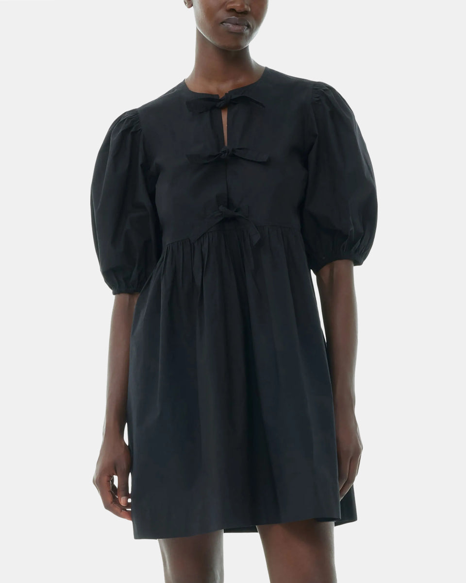 Luźna, czarna sukienka 9005 Poplin Mini Dress Black marki GANNI z okrągłym dekoltem i krótkimi, bufiastymi rękawami, które kończą się nad łokciem. Wiązana z przodu za pomocą sznurków. Odcięta wysoko w talii i rozkloszowana w dół. Wykonana z bawełny organicznej.
-Luźny fason
-100% bawełna organiczna
-Zamów w swoim standardowym rozmiarze