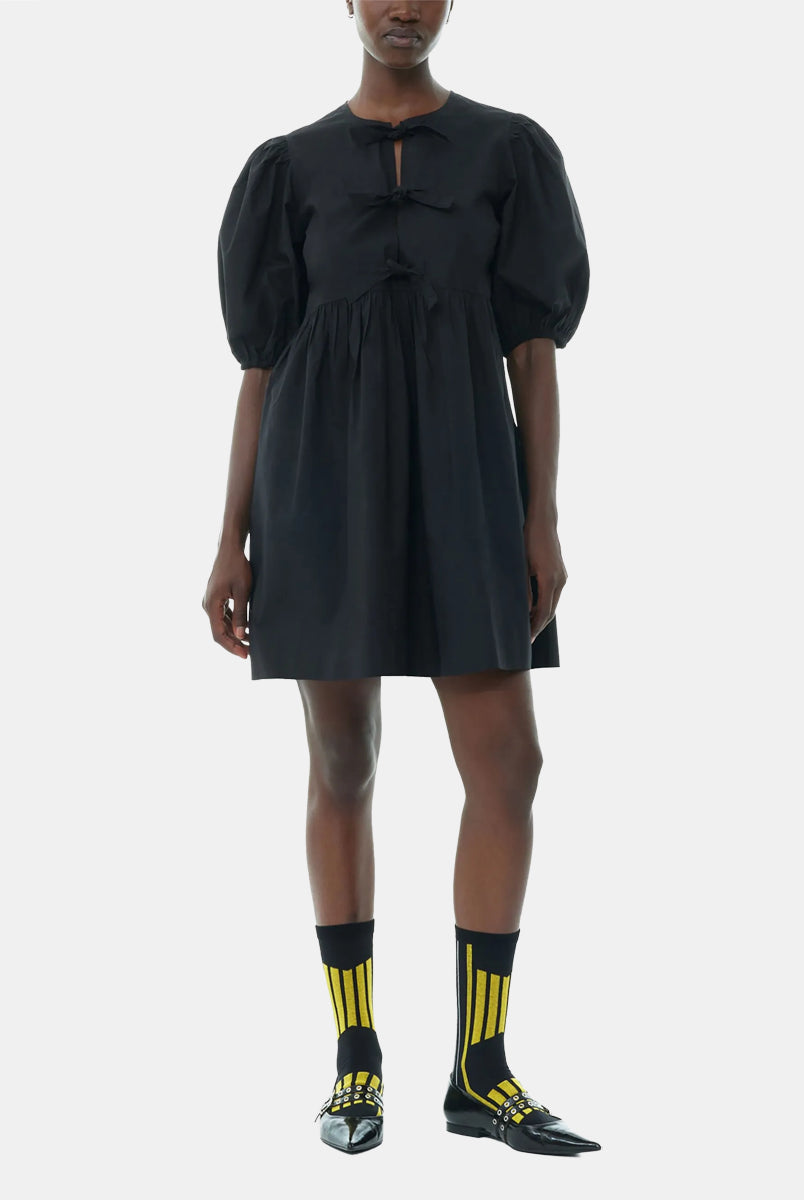 Luźna, czarna sukienka 9005 Poplin Mini Dress Black marki GANNI z okrągłym dekoltem i krótkimi, bufiastymi rękawami, które kończą się nad łokciem. Wiązana z przodu za pomocą sznurków. Odcięta wysoko w talii i rozkloszowana w dół. Wykonana z bawełny organicznej.
-Luźny fason
-100% bawełna organiczna
-Zamów w swoim standardowym rozmiarze