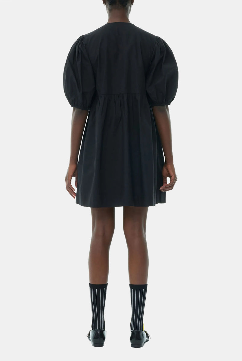 Luźna, czarna sukienka 9005 Poplin Mini Dress Black marki GANNI z okrągłym dekoltem i krótkimi, bufiastymi rękawami, które kończą się nad łokciem. Wiązana z przodu za pomocą sznurków. Odcięta wysoko w talii i rozkloszowana w dół. Wykonana z bawełny organicznej.
-Luźny fason
-100% bawełna organiczna
-Zamów w swoim standardowym rozmiarze