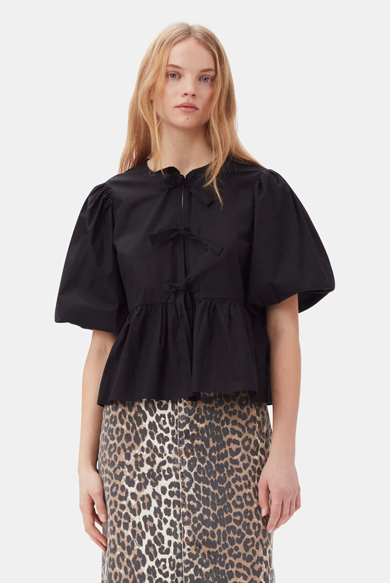 Luźna, czarna bluzka 7364 Cotton Poplin Peplum marki GANNI z okrągłym dekoltem i krótkimi, bufiastymi rękawami o długości do łokcia. Wiązana z przodu za pomocą sznurków. Odcięta wysoko w talii i rozkloszowana u dołu. Wykonana z bawełny organicznej. Idealna do jeansów z wysokim stanem.
-Luźny fason
-100% bawełna organiczna
-Zamów bluzkę w swoim standardowym rozmiarze