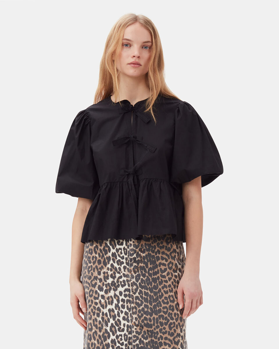 Luźna, czarna bluzka 7364 Cotton Poplin Peplum marki GANNI z okrągłym dekoltem i krótkimi, bufiastymi rękawami o długości do łokcia. Wiązana z przodu za pomocą sznurków. Odcięta wysoko w talii i rozkloszowana u dołu. Wykonana z bawełny organicznej. Idealna do jeansów z wysokim stanem.
-Luźny fason
-100% bawełna organiczna
-Zamów bluzkę w swoim standardowym rozmiarze