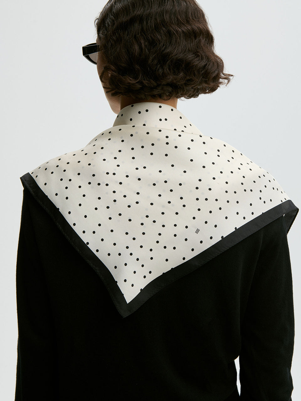 Klasyczna, piękna chusta Poula Black By Malene Birger w ponadczasowy wzór polka dots i kontrastową krawędzią. Wykonana z luksusowego jedwabiu. Zawiąż ją na szyi, nadgarstku lub rączce torebki.