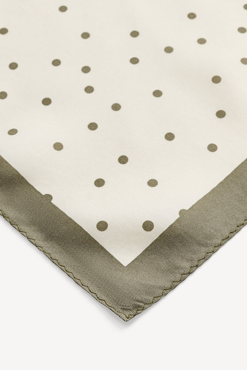 Klasyczna, piękna chusta Poulas Deep Lichen Green By Malene Birger w ponadczasowy wzór polka dots i kontrastową krawędzią. Wykonana z luksusowego jedwabiu. Zawiąż ją na szyi, nadgarstku lub rączce torebki.