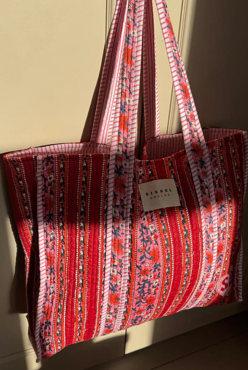 Duża torba typu shopper Pricilla Lavender Bloom SISSEL EDELBO z ręcznie wykonanym, kwiatowym printem i haftem. Wewnątrz posiada płócienną podszewkę i niewielką kieszonkę. Idealna na plażę, weekendowy wyjazd czy zakupy na targu. 