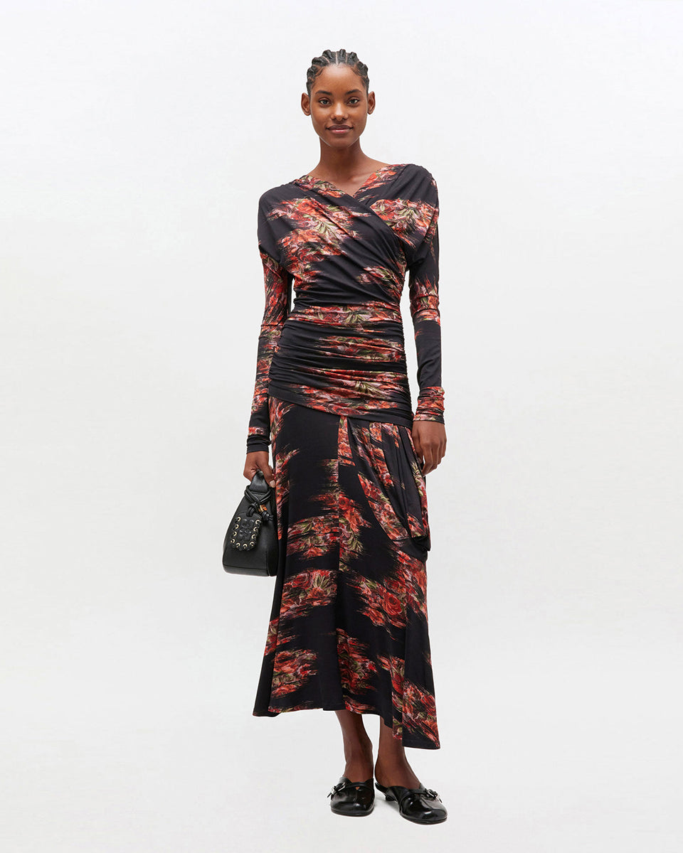 Czarna, maxi sukienka 4380 GANNI Floral Black w kwiatowy print. Sukienka ma asymetryczny dekolt i długie rękawy oraz ciekawe, drapowane marszczenia wzdłuż gorsetu. U dołu ma luźniejszy krój. 