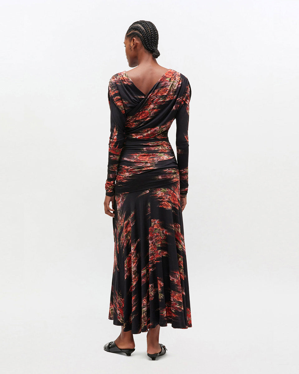 Czarna, maxi sukienka 4380 GANNI Floral Black w kwiatowy print. Sukienka ma asymetryczny dekolt i długie rękawy oraz ciekawe, drapowane marszczenia wzdłuż gorsetu. U dołu ma luźniejszy krój. 