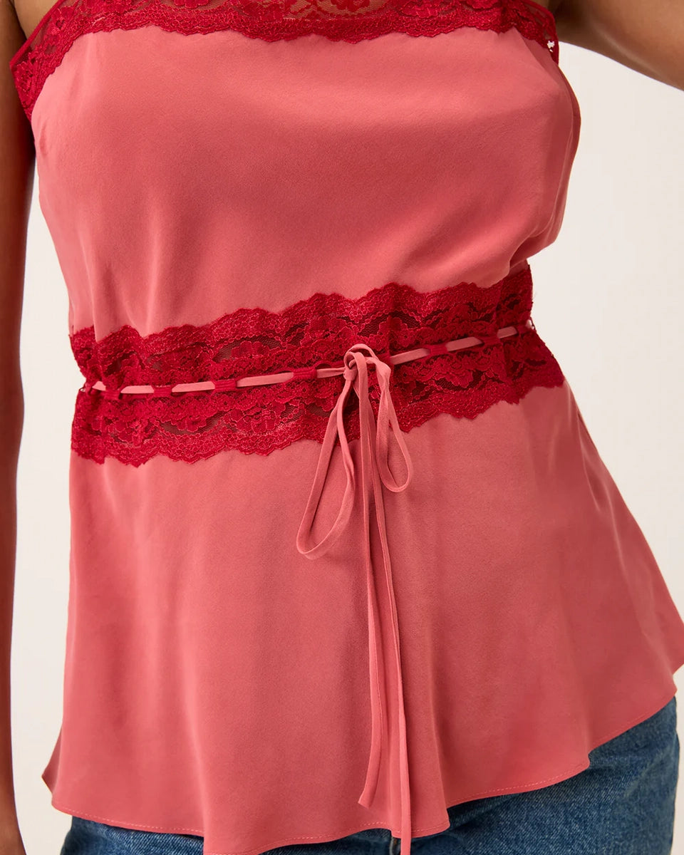 Romantyczny, zwiewny top na cienkich ramiączkach Romy Rouje z prostym dekoltem. Nad biustem i w talii obszyty kontrastową koronką. Zwężany i wiązany w talii. Wykonany z bardzo zwiewnej tkaniny z jedwabiem.