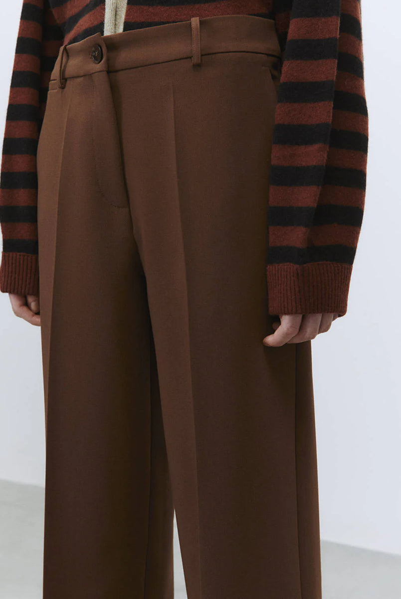 Luźne spodnie Sartoriale Brown z szeroką, prostą nogawką. Posiadają wysoki stan i szlufki umożliwiające noszenie paska. Mają dwie boczne kieszenie z przodu oraz dwie kieszenie z patkami z tyłu. Zapinane na suwak i guzik w pasie. Wykonane z mieszanki wiskozy. Idealne do codziennych, jesiennych stylizacji. 