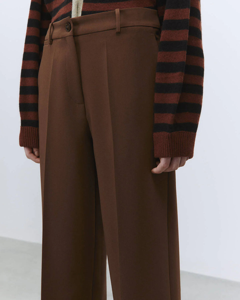 Luźne spodnie Sartoriale Brown z szeroką, prostą nogawką. Posiadają wysoki stan i szlufki umożliwiające noszenie paska. Mają dwie boczne kieszenie z przodu oraz dwie kieszenie z patkami z tyłu. Zapinane na suwak i guzik w pasie. Wykonane z mieszanki wiskozy. Idealne do codziennych, jesiennych stylizacji. 