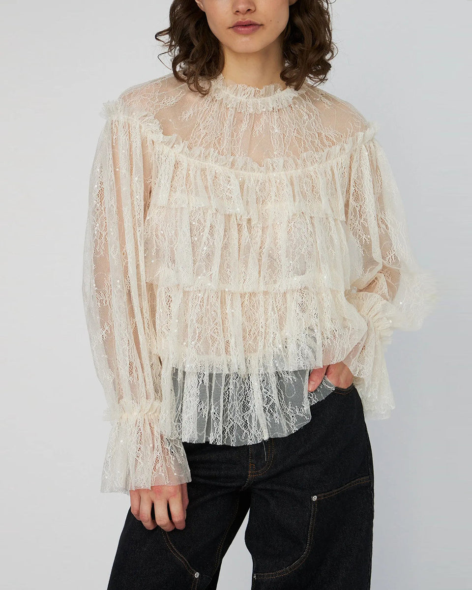 Lekka, koronkowa bluzka Sheer Frill Lace marki STELLA NOVA z długimi rękawami i falbankami na korpusie. Dekolt jest zapinany z tyłu na mały guzik z pętelką. Bluzka nie posiada podszewki. 