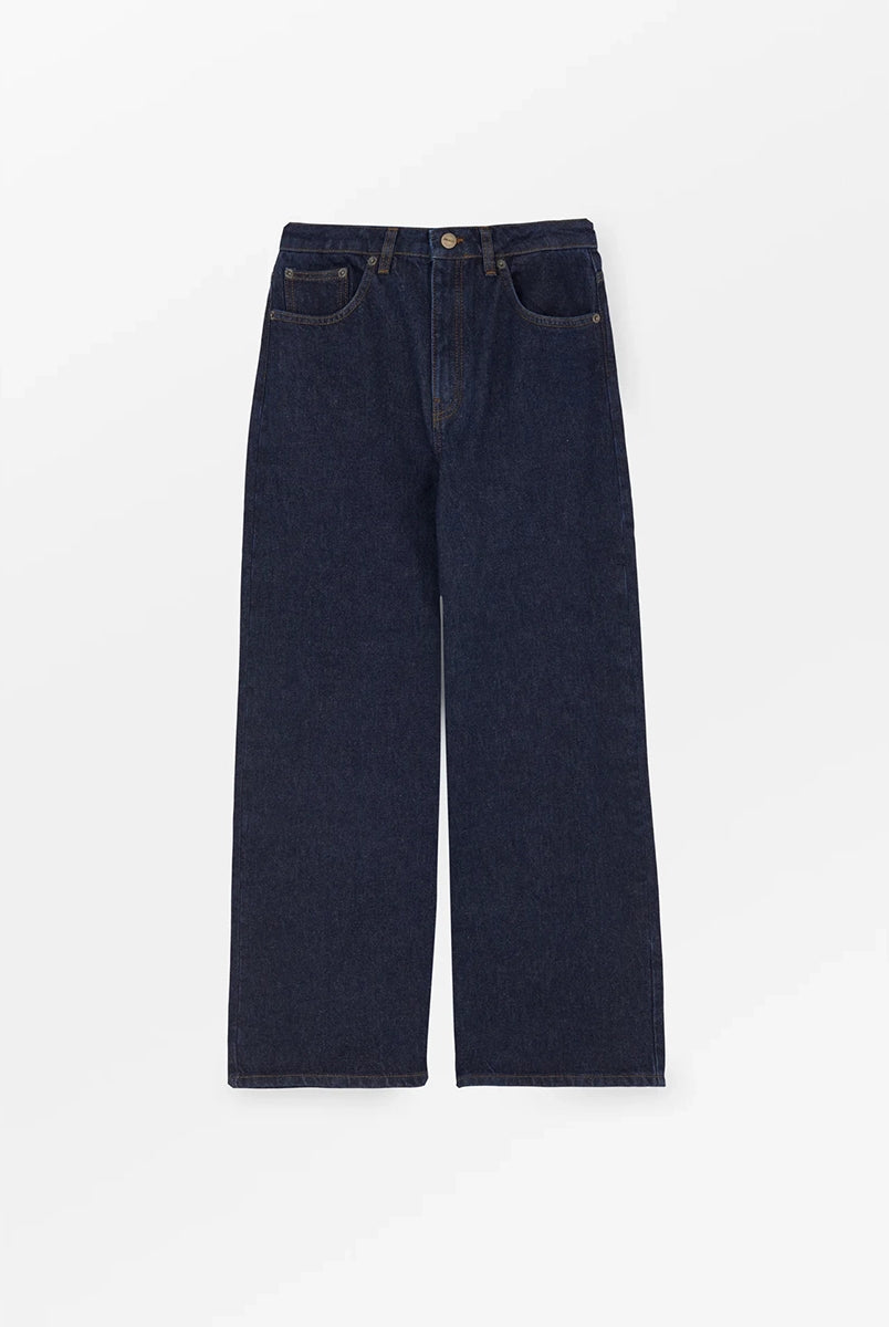 Luźne jeansy Willow Indigo Blue SKALL z obniżonym stanem i szerokimi, prostymi nogawkami. Posiadają kieszenie, szlufki na pasek i haftowane logo z tyłu w pasie. Jeansy maja standardową długość. Wykonane ze sztywnego denimu z bawełny organicznej.