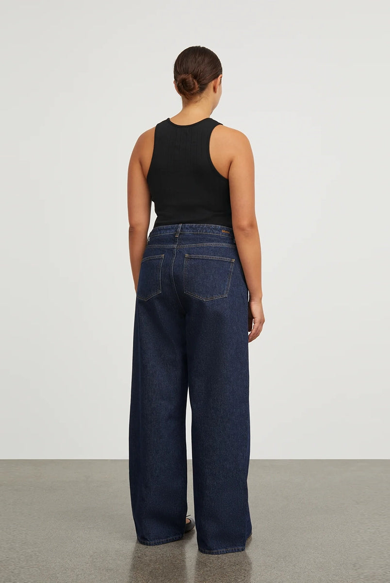Luźne jeansy Willow Indigo Blue SKALL z obniżonym stanem i szerokimi, prostymi nogawkami. Posiadają kieszenie, szlufki na pasek i haftowane logo z tyłu w pasie. Jeansy maja standardową długość. Wykonane ze sztywnego denimu z bawełny organicznej.