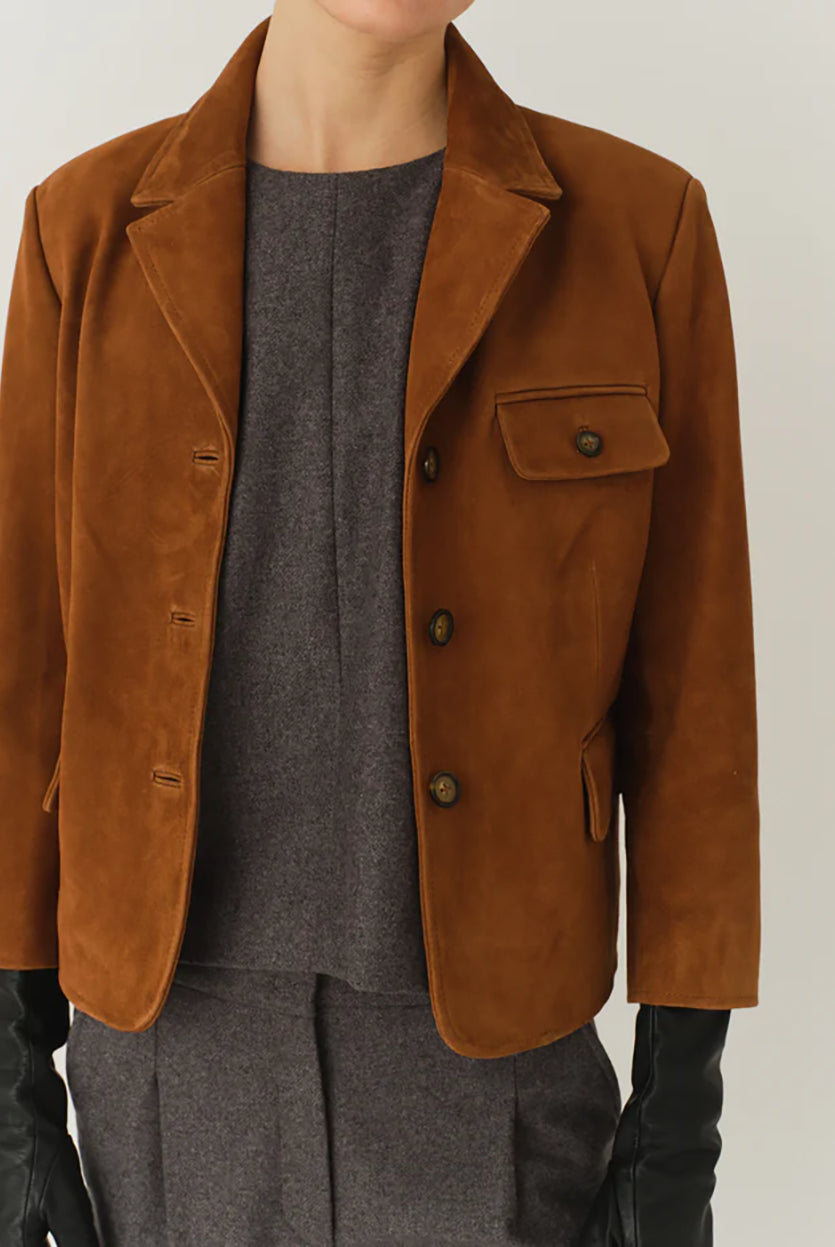 Krótka, dopasowana kurtka Suede Fitted Hazelnut z kołnierzykiem, dwoma przednimi kieszeniami i kieszonką na piersi. Zapinana guziki. Wykonana z zamszu ze skóry koziej. Dopasowany fason nadaje kurtce kobiecy charakter z eleganckim akcentem. 