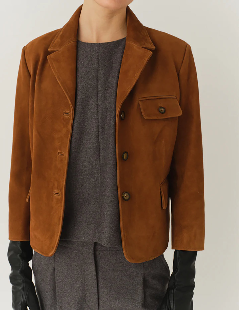 Krótka, dopasowana kurtka Suede Fitted Hazelnut z kołnierzykiem, dwoma przednimi kieszeniami i kieszonką na piersi. Zapinana guziki. Wykonana z zamszu ze skóry koziej. Dopasowany fason nadaje kurtce kobiecy charakter z eleganckim akcentem. 