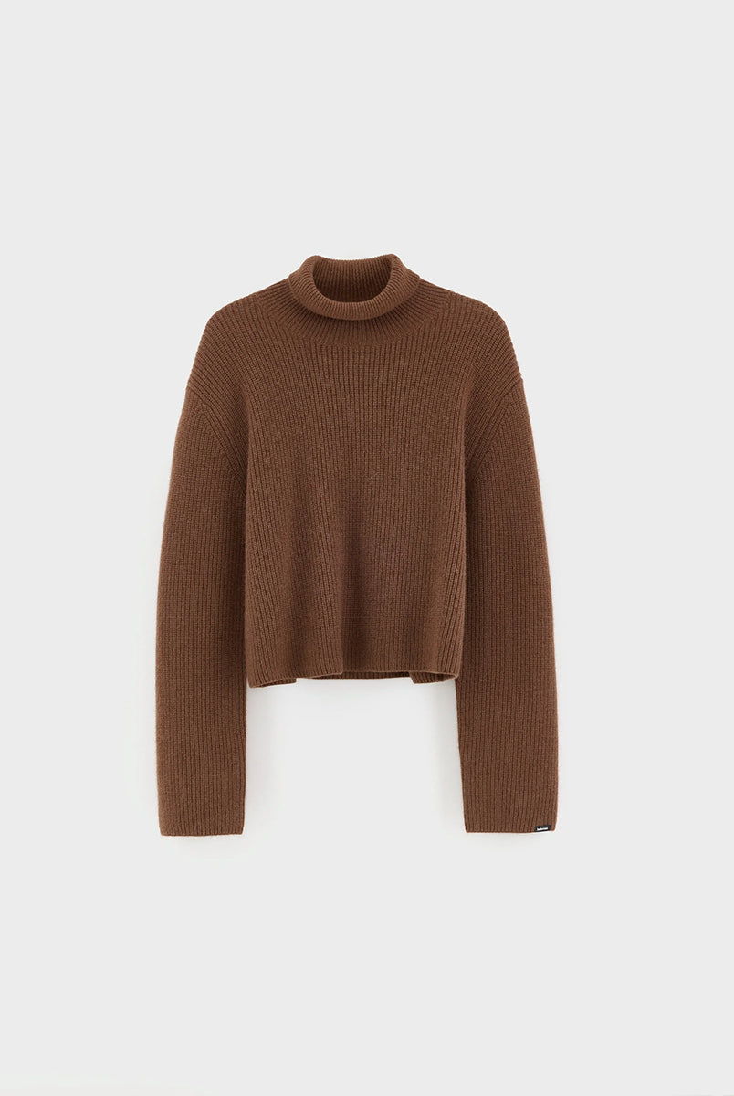 Luźny, brązowy sweter z golfem Synin Tiramisu Bellerose wykonany w 100% z kaszmiru. Posiada proste, szerokie rękawy z wywiniętymi mankietami i kołnierz typu funnel neck. Ma swobodny, lekko luźny krój oraz wyraźną, prążkowaną strukturę materiału. Wysoki, otulający golf dodaje mu szyku i doskonale sprawdza się w chłodniejsze dni, tworząc stylową kompozycję z ciemnymi spodniami.
-Golf
-Długie, szerokie rękawy
-100% kaszmir