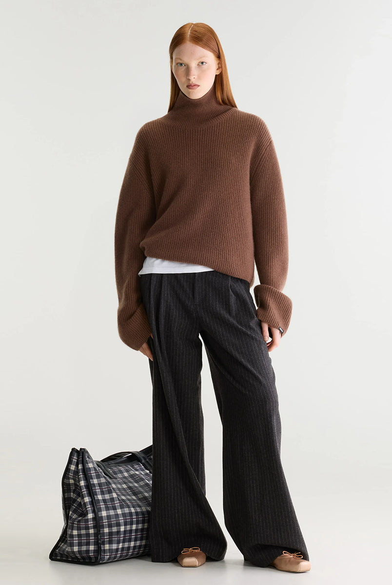 Luźny, brązowy sweter z golfem Synin Tiramisu Bellerose wykonany w 100% z kaszmiru. Posiada proste, szerokie rękawy z wywiniętymi mankietami i kołnierz typu funnel neck. Ma swobodny, lekko luźny krój oraz wyraźną, prążkowaną strukturę materiału. Wysoki, otulający golf dodaje mu szyku i doskonale sprawdza się w chłodniejsze dni, tworząc stylową kompozycję z ciemnymi spodniami.
-Golf
-Długie, szerokie rękawy
-100% kaszmir