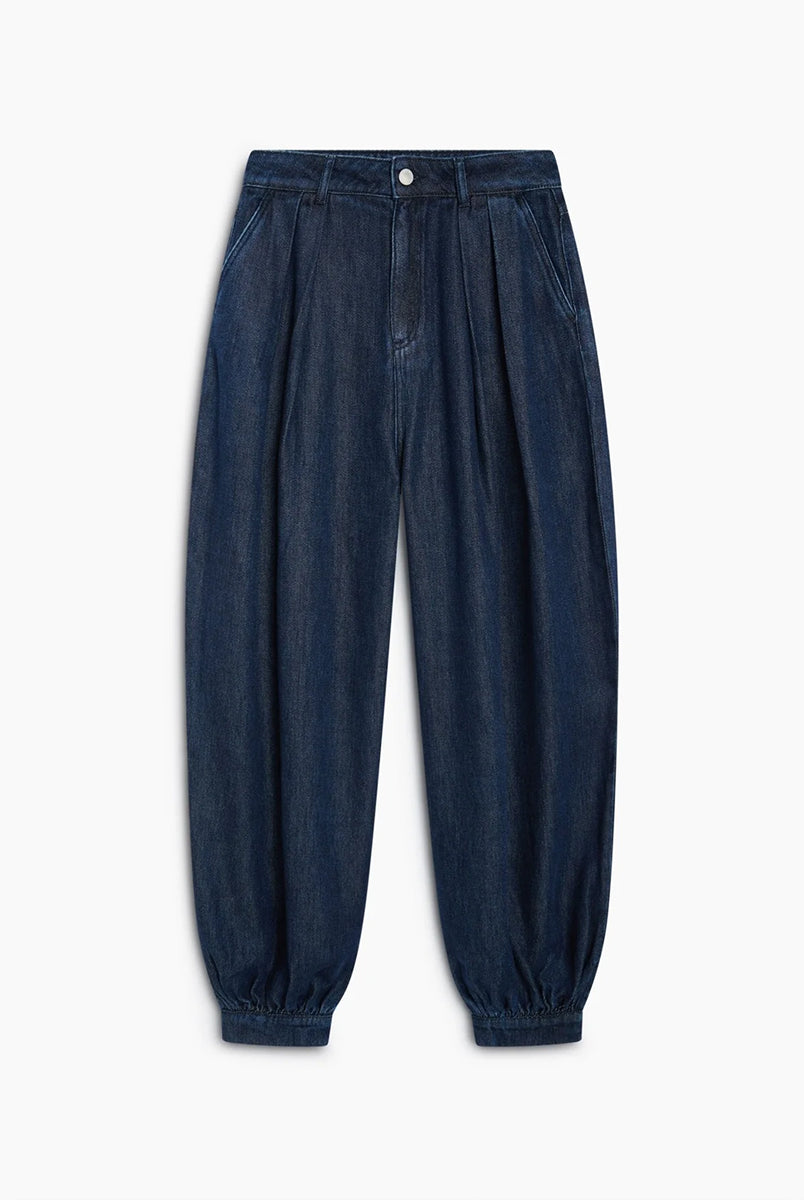 Luźne spodnie typu haremki Tencel TNS Dark Blue Denim z obszernymi nogawkami, które zyskują objętość dzięki zakładkom w talii oraz mankietom u dołu. Mają klasyczne zapięcie na guzik i zamek, kieszenie boczne oraz kieszenie naszywane z tyłu. Całość dopełnia charakterystyczny haft marki na tylnej części pasa. Spodnie są nową interpretacją klasycznego jeansu. Wykonane z wysokiej jakości denimu tencel, pięknie się układają i są lekkie w noszeniu.
-Luźny fason z bufiastymi nogawkami
-Wysokiej jakości den
