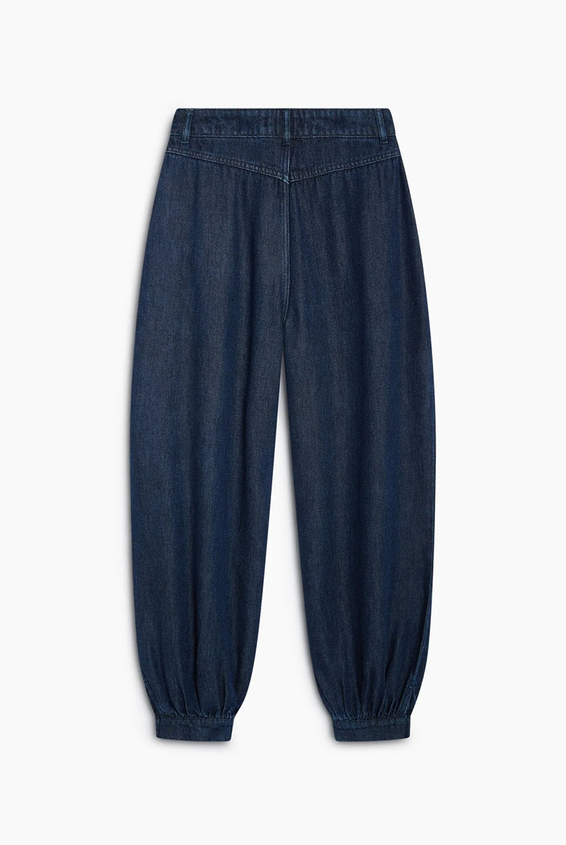 Luźne spodnie typu haremki Tencel TNS Dark Blue Denim z obszernymi nogawkami, które zyskują objętość dzięki zakładkom w talii oraz mankietom u dołu. Mają klasyczne zapięcie na guzik i zamek, kieszenie boczne oraz kieszenie naszywane z tyłu. Całość dopełnia charakterystyczny haft marki na tylnej części pasa. Spodnie są nową interpretacją klasycznego jeansu. Wykonane z wysokiej jakości denimu tencel, pięknie się układają i są lekkie w noszeniu.
-Luźny fason z bufiastymi nogawkami
-Wysokiej jakości den